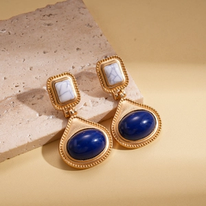 Nahaufnahme von Vintage-Goldohrringen mit Marmor-Rechteck und blauem Harz-Tropfen