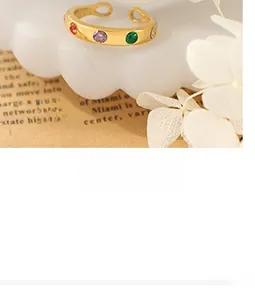 Detail of adjustable brass ring with colorful zircon stones and polished gold plating