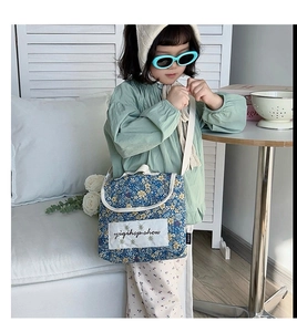 Detail of blue floral quilted crossbody bag for kids with embroidered patch and strap