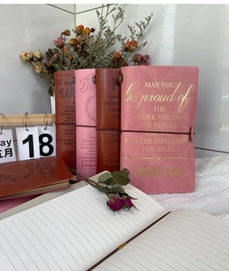 Macro detail of leather notebook featuring inspirational quotes and lined paper inner pages