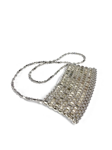 Macro view of hand-woven silver metal sequins and mesh structure on a crossbody bag