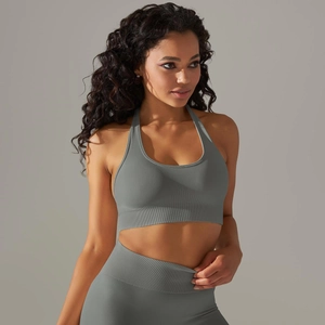 Detailed texture of seamless light gray knitted sports bra with halter neck and ribbed hem
