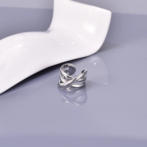 Detailed top view of silver multi-layer crossover open ring on reflective stand
