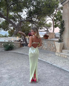 Detail of lime green sequin backless maxi dress with thin straps and a high back slit