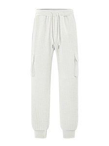 Close-up of cream white men's cargo pants showing quilted waffle texture and drawstring detail
