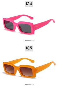 Detail showing bright pink and orange rectangular sunglasses with gold dot accents