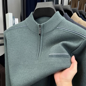Detail of grey-green men's knit sweater showing premium textured fabric and half-zip collar