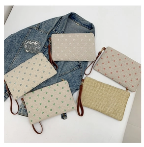 Detailed flat lay of casual linen clutch bags with colorful patterns and wrist straps