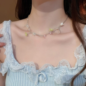 Détail d'un collier de fleurs en perles avec pétales roses et jaunes et perles