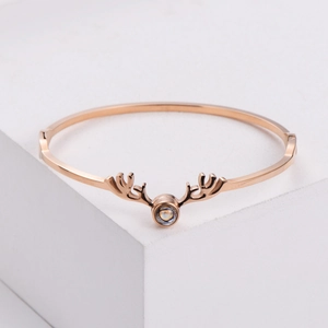 Bracciale rigido corna di cervo oro rosa con pietra di proiezione su sfondo bianco