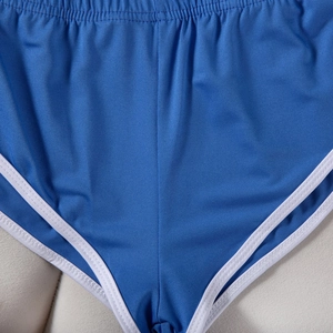 Nahaufnahme der Doppelnähte und des atmungsaktiven blauen Strickstoffs der Sportshorts