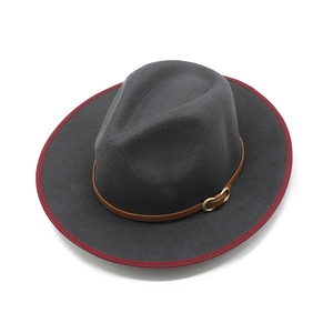 Detail of dark grey wool fedora featuring red bound edge and leather band with gold buckle