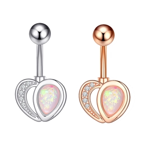 Close-up of heart-shaped belly button rings with zircon inlay in silver and rose gold