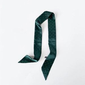Detail eines dunkelgrünen Satin-Twilly-Schals mit weißen Punkten auf weißem Grund