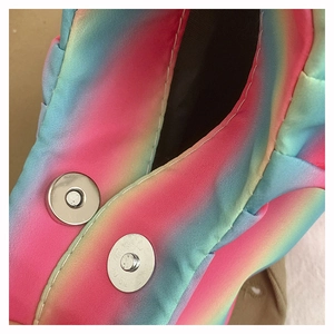 Detailed macro shot of the rainbow pleated shoulder bag showing magnetic closures