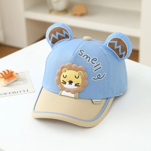 Détail d'une casquette de bébé avec oreilles 3D et patch lion en bleu et beige
