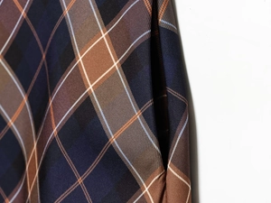 Detailed close-up of blue and brown plaid fabric showing side pocket and stitching quality