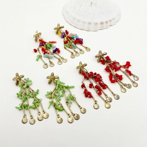 Flat lay of colorful coral beaded tassel earrings with metal shell charms on white background