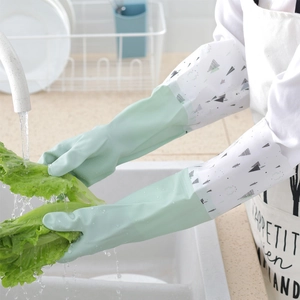 Green waterproof fleece-lined household gloves used for washing vegetables in kitchen sink