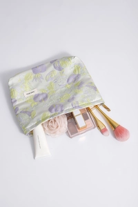 Close-up of floral makeup bag with gold zipper showing interior storage for cosmetics