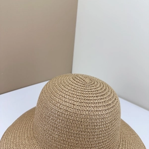 Dettaglio di un cappello di paglia naturale marrone con trama a spirale e consistenza