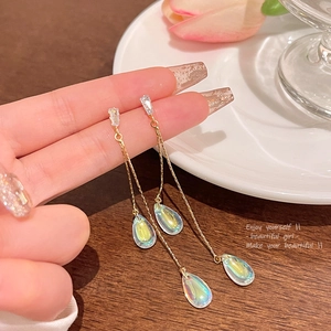 Detail of elegant gold drop earrings with rainbow pearls and sparkling zircon stones