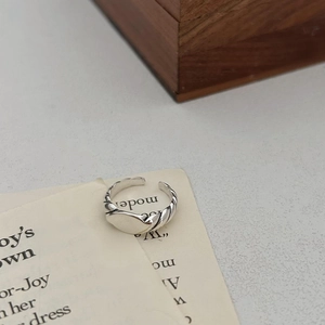 Minimalist 925 sterling silver twisted open ring on aesthetic vintage paper background