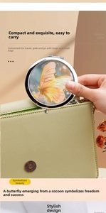 Close-up of portable folding metal makeup mirror with orange butterfly pattern and green bag