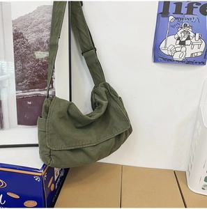 Detail view of army green canvas crossbody bag with adjustable strap and side pockets