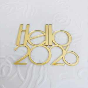 Mirror Gold Acryl Hello 2026 Kuchendeckel Detail auf elegantem weißem strukturiertem Grund