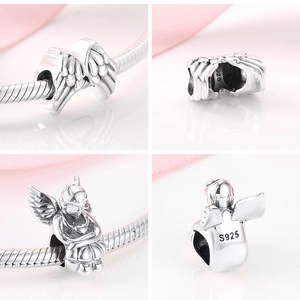 Detailed view of S925 sterling silver angel wing and cherub charms with hallmarks