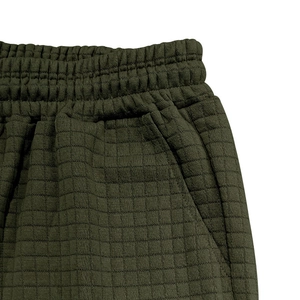 Detail of olive green waffle knit shorts featuring elastic waistband and side pockets