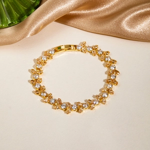 Detailed close-up of a gold-plated bracelet featuring amber and clear zircon stones