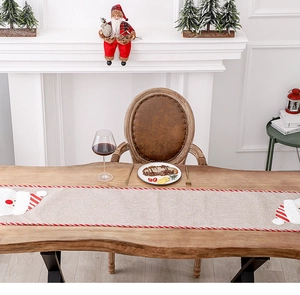 Linen Christmas table runner featuring Santa Claus embroidery and festive red stripes