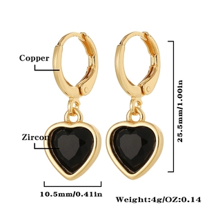 Détail des boucles d'oreilles cœur en cuivre doré serties de zircons noirs