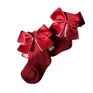 Red festive baby high socks with large satin bow in Spanish style for Christmas and New Year