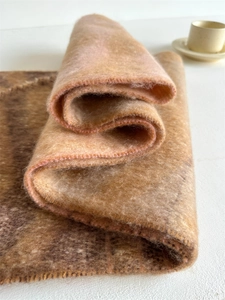 Gros plan d'une écharpe léopard avec texture polaire et bordure cousue rose