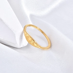 Macro detail of minimalist gold stainless steel ring with sunburst engraving pattern