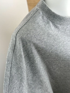 Detailed close-up of gray knitted cotton T-shirt neckline with premium double stitching