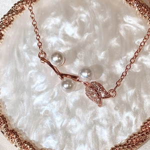 Rose gold pearl necklace with leaf design and sparkling zircon pavé on round tray