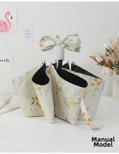 Detail of floral folding umbrella with elegant orange blossoms and matching bow tie