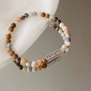 Makro-Detail der Silberröhre mit Sutra und mehrfarbigen Perlen am Zen-Armband