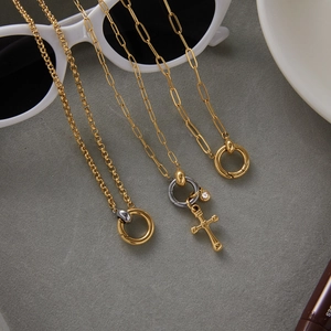 Detail of 18K gold and silver mixed color necklace with cross pendant on sunglasses