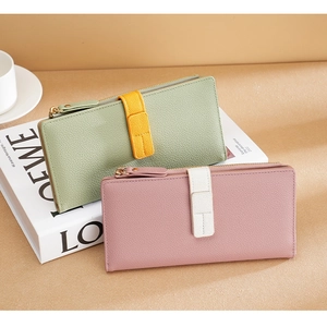 Detail of long contrast color PU leather wallets with gold zippers and litchi grain texture