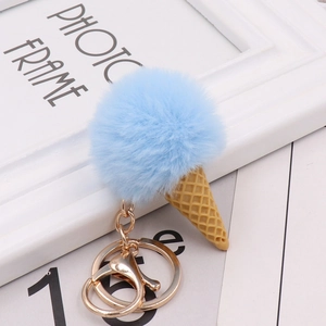 Close-up of a blue faux fur ice cream keychain with waffle cone and golden metal hardware