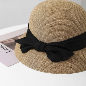 Eleganter Strohhut mit breiter Krempe und schwarzer Schleife für den Strandurlaub
