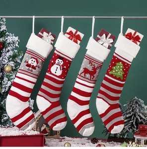 Detail of four knitted Christmas stockings with Santa, snowman, and reindeer patterns