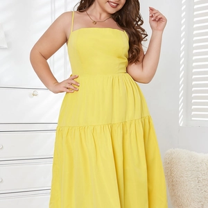 Detail of plus size bright yellow maxi dress featuring thin straps and pleated hem
