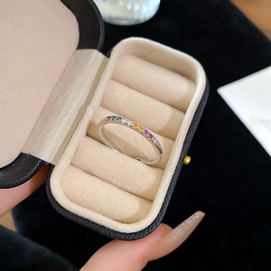 Macro shot of colorful rainbow zircon stones set in a silver ring displayed in a jewelry box
