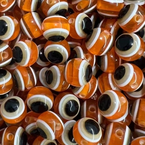 Macro detail of orange and white striped resin beads for DIY jewelry making